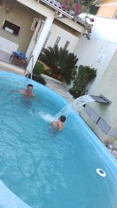dos personas en una piscina con una fuente en Pousada Vó Santina en Protásio Alves