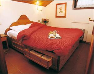 Un dormitorio con una cama con una bandeja de comida. en RESIDENCE-RESORT BORGO AL SOLE en Sappada