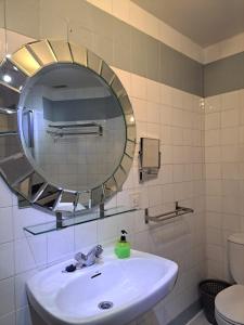 y baño con lavabo blanco y espejo. en La Casona del Pinar Albergue, en San Rafael