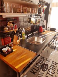 a kitchen with a sink and a wooden counter top at Sofia Palms: Modern apartment with a large terrace in Sofia
