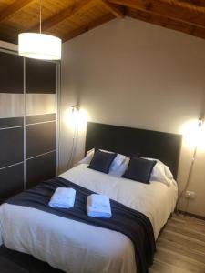 une chambre avec un grand lit avec deux serviettes dessus dans l'établissement PARALELO hospedaje vacacional, à El Bolsón