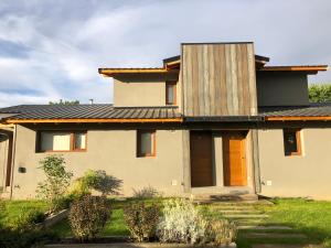 a house with a metal roof at PARALELO hospedaje vacacional in El Bolsón