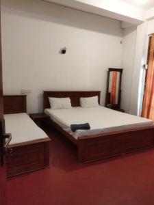 a bedroom with two beds and a window at New Dulmi Guest House. in Denipitiya