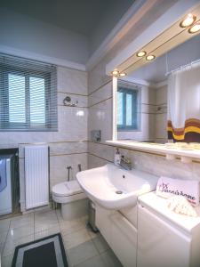 a bathroom with a sink and a toilet and a mirror at Yianni's Home-Comfort Apartment in Volos in Volos +42 photos