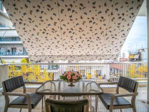 a table with chairs and a vase of flowers on a balcony at Yianni's Home-Comfort Apartment in Volos in Volos