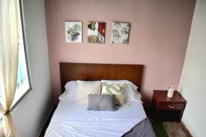 a bedroom with a bed with three pictures on the wall at Casa Colinas in Buenaventura