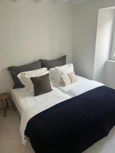 uma cama grande com lençóis e almofadas preto e branco em Casa Olarias em Grândola