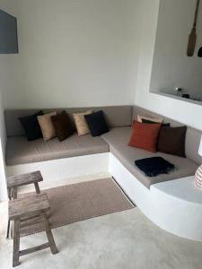 uma sala de estar com um sofá com muitas almofadas em Casa Olarias em Grândola
