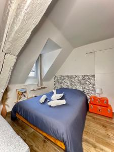 um quarto com uma cama azul com toalhas em Le charme Dubois em Dijon