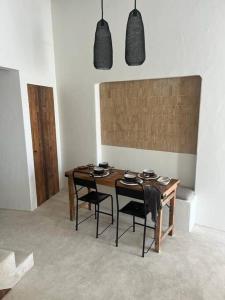 a dining room with a table and chairs and lights at Casa Olarias in Grândola