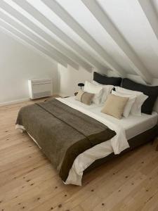 um quarto com uma cama grande num sótão em Casa Olarias em Grândola