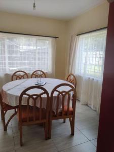 a dining room with a table and four chairs at Townhouse Upper Hill Nairobi 2 in Nairobi