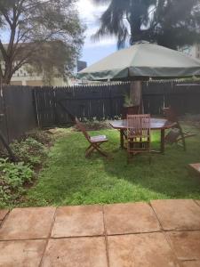 a table and chairs with an umbrella in a yard at Townhouse Upper Hill Nairobi 2 in Nairobi