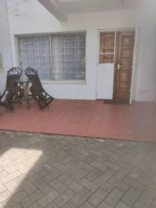a patio with two benches and a table in front of a building at Townhouse Upper Hill Nairobi 2 in Nairobi