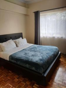 a bedroom with a large bed with a window at Townhouse Upper Hill Nairobi 2 in Nairobi