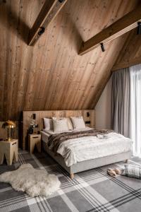 a bedroom with a large bed and wooden ceilings at Owce Dwie in Zakopane