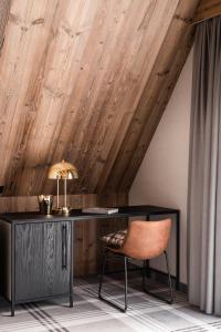 a desk and a chair in a room with wooden ceilings at Owce Dwie in Zakopane