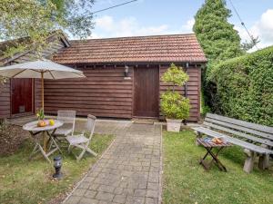 a patio with a bench and a table and an umbrella at 1 Bed in St Neots 78984 in Wyboston