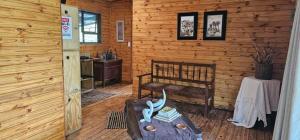 a room with a bench and a table in a log cabin at Marepe Flora Mountain View in Kampersrus AH