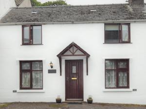 a white house with a brown door and windows at 2 bed property in Gower 78344 in Reynoldston