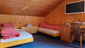 a room with two beds in a wooden room at Gasthaus Rössli in Brülisau