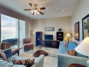 ein Wohnzimmer mit einem blauen Sofa und einem Deckenventilator in der Unterkunft Precious Memories - Diamond Beach 513 in Galveston