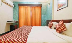 1 dormitorio con 1 cama grande con almohadas rojas y blancas en FabHotel Prime KB's Grand, en Shirdi