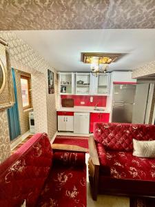 a living room with a red couch and a kitchen at İmmortal Hotel İstanbul in Istanbul