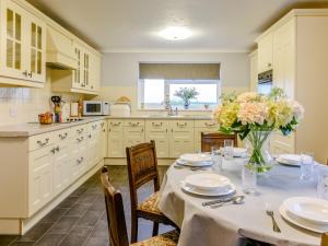 a kitchen with a table with a vase of flowers at 3 Bed in Langtree 79041 in Langtree