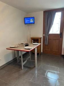 a table in a room with a tv on the wall at Très bel Appartement bleu in Montclar