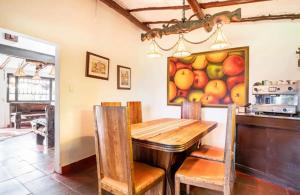 a dining room with a table and a painting of fruit at HERMOSA CASA CAMPESTRE 