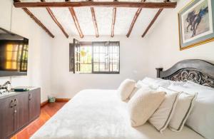 um quarto com uma grande cama branca e um lavatório em HERMOSA CASA CAMPESTRE 