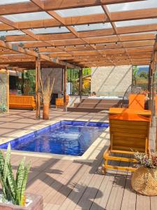 a patio with a swimming pool and a wooden pergola at HERMOSA CASA CAMPESTRE 