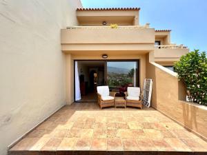 einen Balkon eines Hauses mit zwei Stühlen in der Unterkunft Apartment AP1, pool, 200 meters to Los Roques Beach in Los Realejos