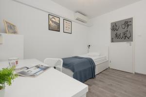 a white room with a bed and a table at Apartments City Center by Renters in Warsaw