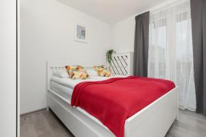 a white bedroom with a red blanket on a bed at Apartments City Center by Renters in Warsaw