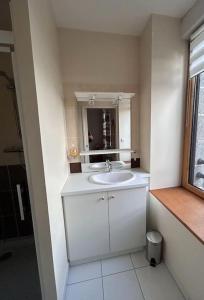 a white bathroom with a sink and a mirror at L'Armateur, Pordic centre in Pordic