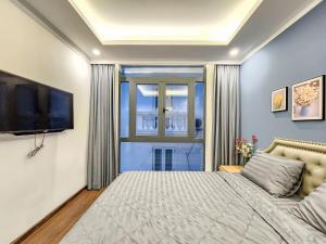 - une chambre avec un lit et une télévision à écran plat dans l'établissement Golden Sun Hotel Apartments, à Hô-Chi-Minh-Ville