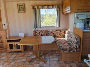 een woonkamer met een tafel en een bank bij Montana-Camping-Fayon in Fayón