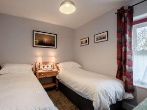 two twin beds in a room with a window at 2 Bed in Aberdovey 80399 in Llwyngwril