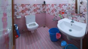 Natureland Homestay في كوتايم: حمام وردي اللون مزود بحوض غسيل ومرحاض +50 صورة