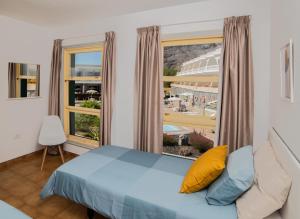 een slaapkamer met een bed en een groot raam bij Apartamentos Charco del Conde in Valle Gran Rey