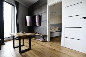 uma sala de estar com uma mesa e uma cama em APARTAMENT TOPaZ 30 em Konin