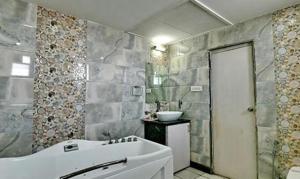y baño con bañera blanca y lavamanos. en FabHotel Prime Simna International, en Muzaffarpur