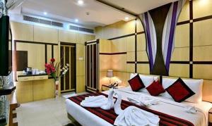 a bedroom with a large white bed with red pillows at FabHotel Prime Simna International in Muzaffarpur
