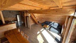 una vista sul soffitto di un soggiorno e di una cucina in una baita di tronchi di Cabana Armonia Naturii a Avrig