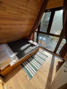 an overhead view of a bed in a wooden cabin at Cabana Armonia Naturii in Avrig