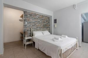 a bedroom with a bed and a brick wall at Petralona semi-basement apartment for 2 persons in Athens