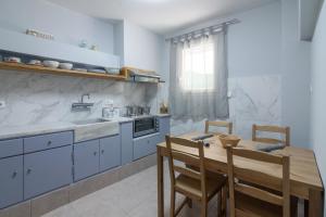 uma cozinha com armários azuis e uma mesa de madeira em Petralona semi-basement apartment for 2 persons em Atenas