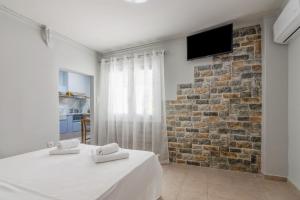 a bedroom with two beds and a stone wall at Petralona semi-basement apartment for 2 persons in Athens